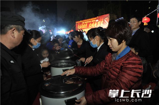 “中國好人”賀國輝攜手長沙市“最美志愿者”彭金來為前來參加活動的居民們送上熱騰騰的湯圓,，也將“團圓”祝福送到居民心里,。照片均為長沙晚報記者 王志偉 攝