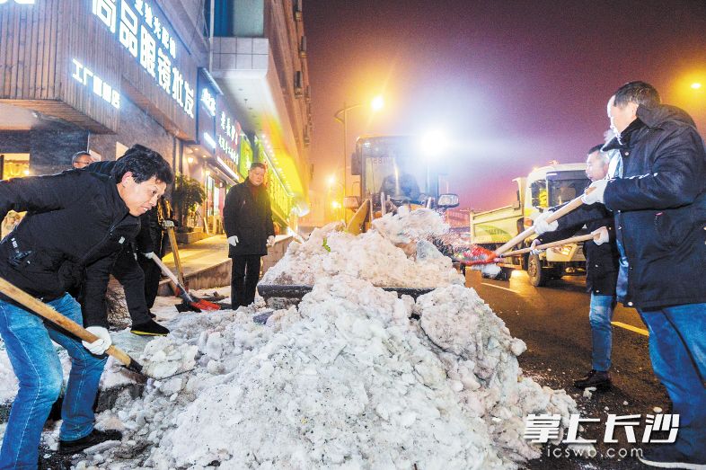 昨晚9時(shí),，車站北路，芙蓉區(qū)湘湖街道城管工作人員正在對(duì)路邊的積雪進(jìn)行統(tǒng)一清理,。 長(zhǎng)沙晚報(bào)記者 鄒麟 攝