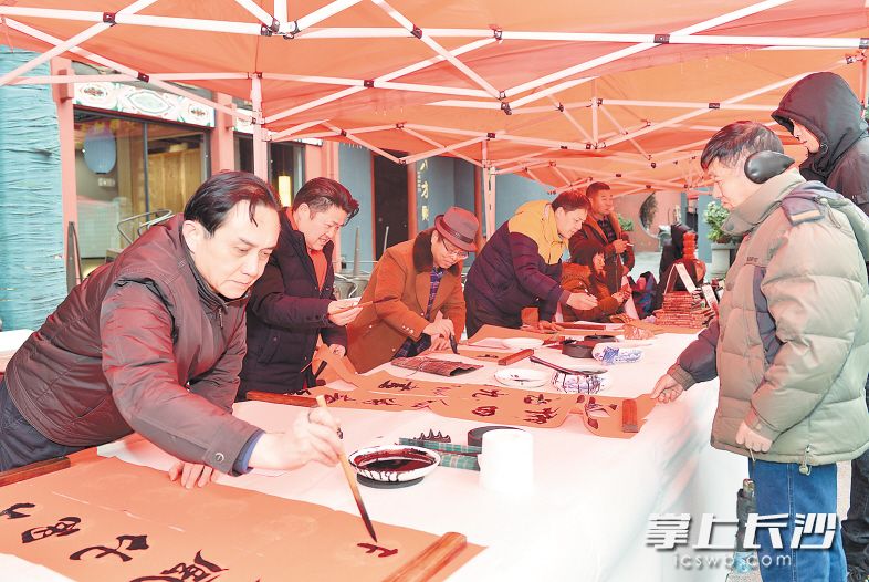 活動(dòng)現(xiàn)場(chǎng)，書法家們正在給市民們書寫春聯(lián),?！　【鶠殚L沙晚報(bào)記者 羅杰科 鄒麟 攝影報(bào)道