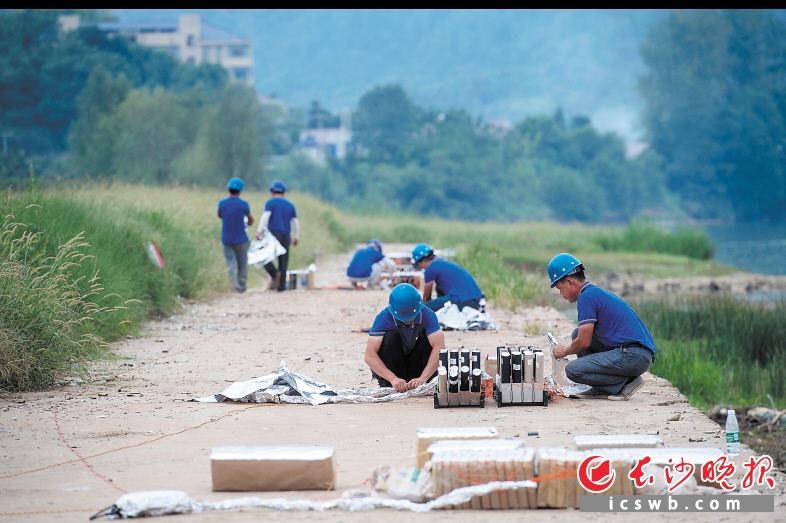 　　工作人員用錫紙為煙花組做防潮防火工作，這是正式燃放前最后的安全檢查工作,。點(diǎn)火線路和煙花組的防護(hù),、煙花角度的調(diào)整、煙花點(diǎn)位距離的確定以及每組煙花的電子線路連接控制等所有環(huán)節(jié),，工作人員都須集中精神做好,。