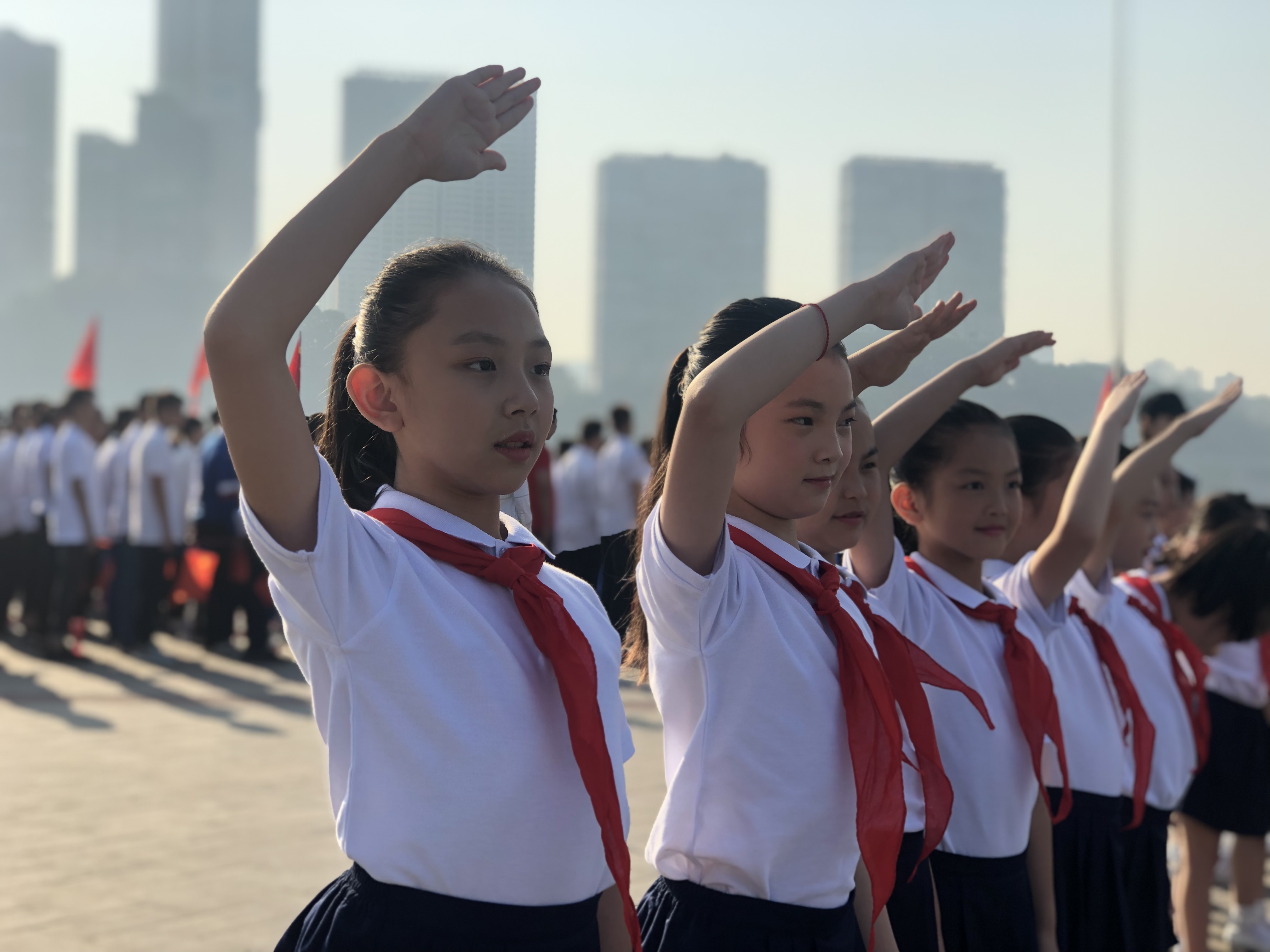 國歌響起,，少先隊員們面向五星紅旗敬禮。