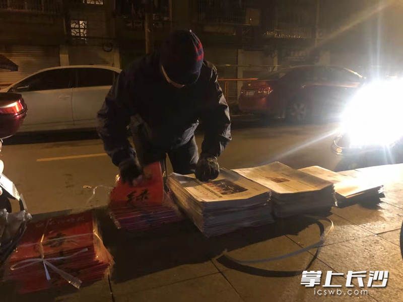 凌晨5時(shí)許,，借著微弱的路燈和電動(dòng)車燈，發(fā)行員們抓緊時(shí)間夾報(bào)。
