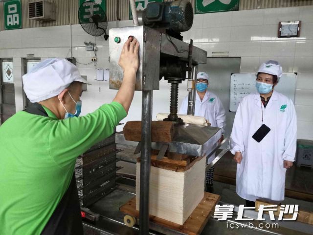 長(zhǎng)沙市利利平食品有限公司董事長(zhǎng)周利平（右一）在豆制品生產(chǎn)車(chē)間檢查產(chǎn)品質(zhì)量,。
