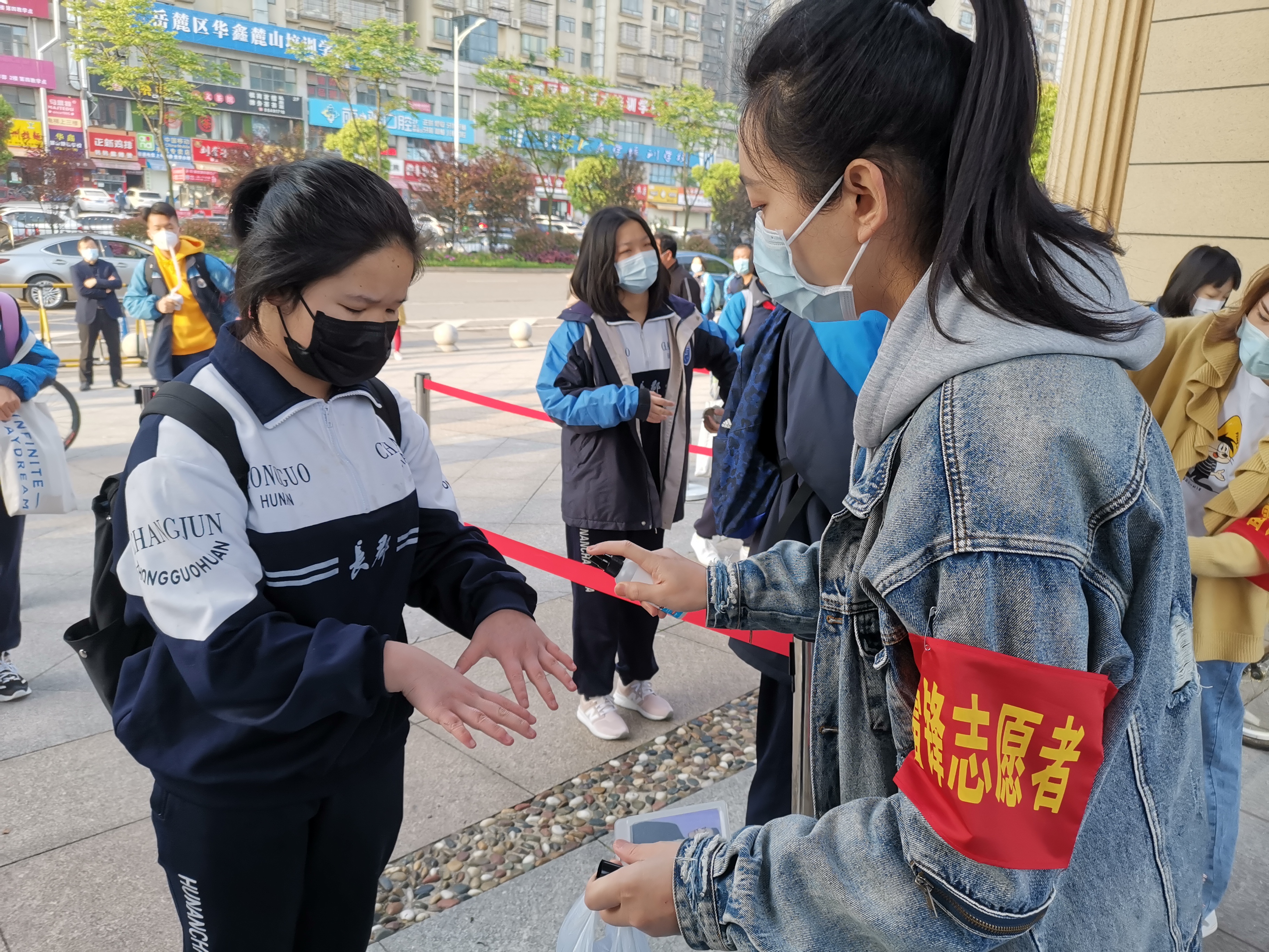 在長郡濱江中學(xué),，“雷鋒志愿者”們堅守校門，為復(fù)學(xué)學(xué)生開展測溫,、手部消毒等志愿服務(wù),。