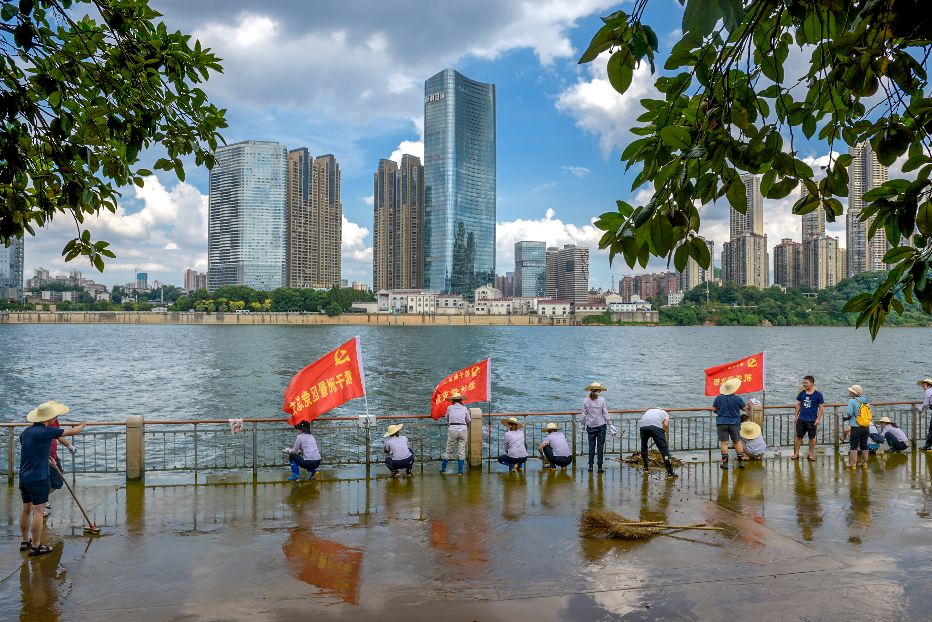 今天下午，橘子洲親水平臺,，湘江洪流剛剛退去,，地面上積了一層厚厚的淤泥，橘子洲景區(qū)管理處工作人員已經(jīng)開始進(jìn)行熱火朝天清淤工作,，水槍,、掃把、鏟子齊上陣,，擦洗欄桿,、沖洗地面，忙得不亦樂乎,。