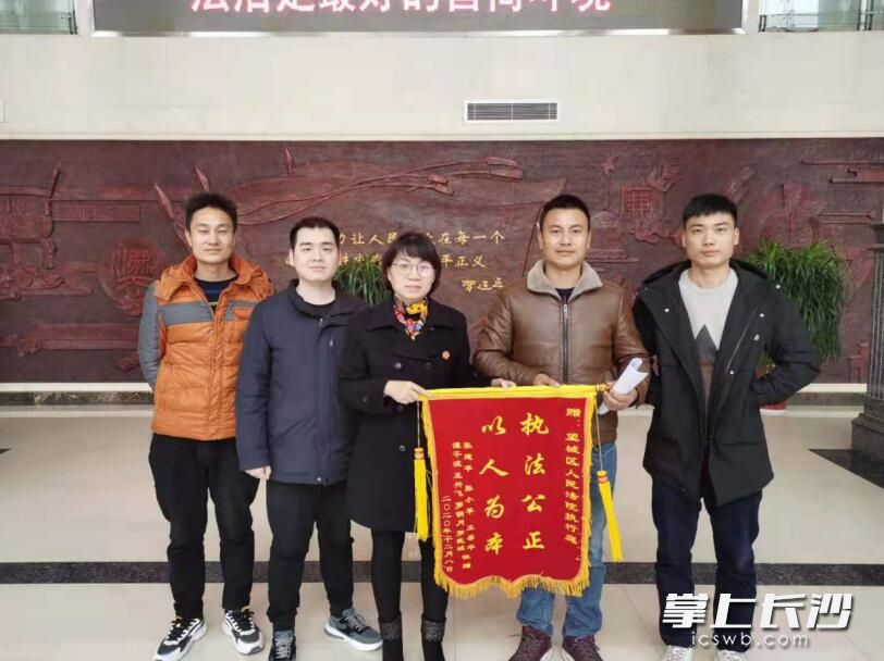 幾名申請執(zhí)行人向執(zhí)行法官送來“以人為本 執(zhí)法公正”的錦旗，并對法官再三表示謝意,。