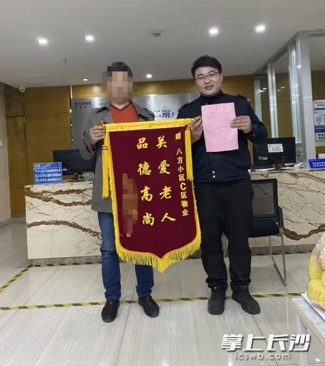 心懷感激的王先生一家特意制作了一面錦旗和一封感謝信,，來到八方小區(qū)物業(yè)中心送給收留老人的好心保安,。八方小區(qū)物業(yè)供圖