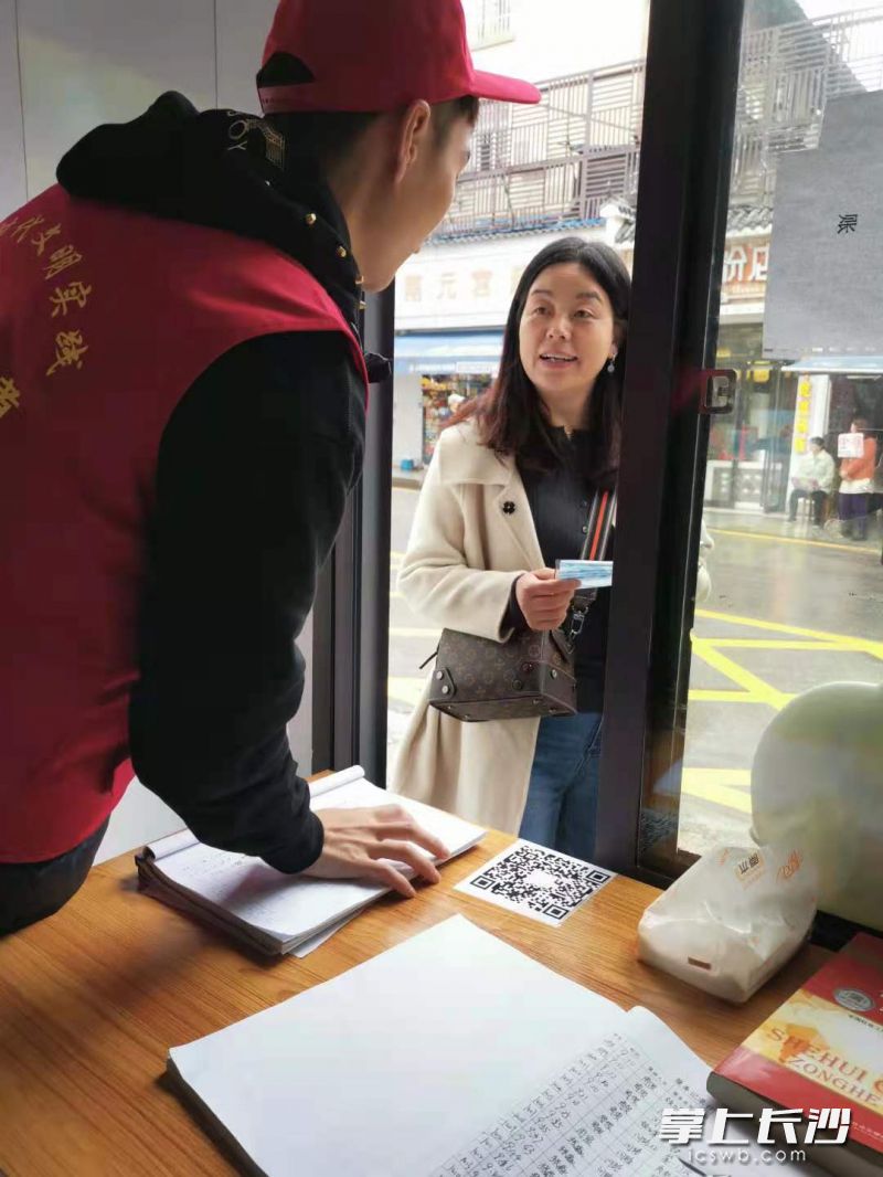 志愿者正在為群眾發(fā)放免費口罩,。全媒體記者 顏家文攝