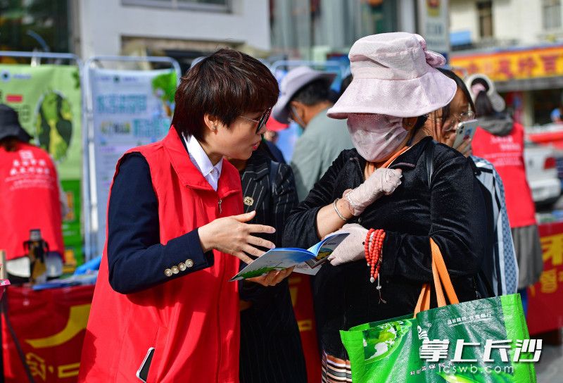 湖南短援隊(duì)員頂著烈日為過(guò)往群眾宣傳環(huán)保理念并發(fā)放知識(shí)手冊(cè),。