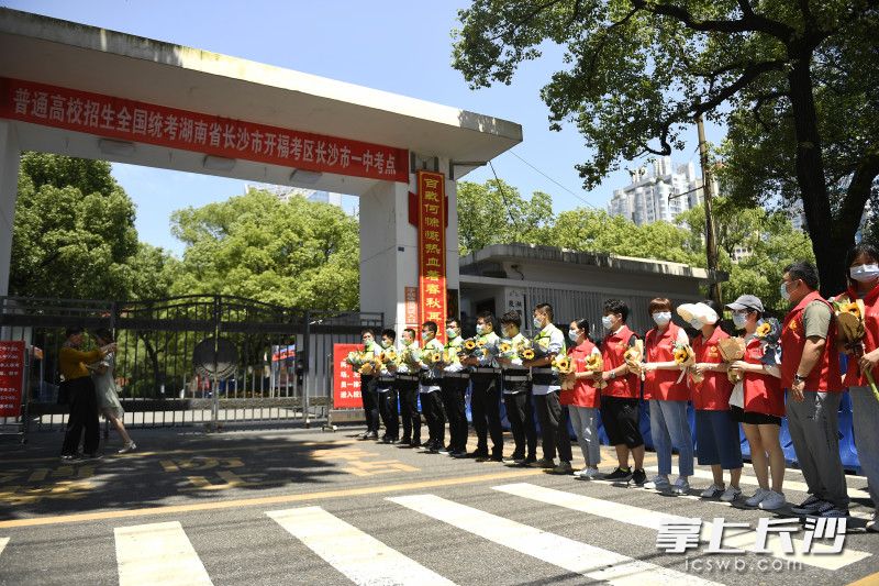 上午第一堂考試結(jié)束之后,，志愿者守護(hù)在長(zhǎng)沙市一中門(mén)口,，為考生獻(xiàn)上向日葵。長(zhǎng)沙晚報(bào)全媒體記者 黃啟晴 攝