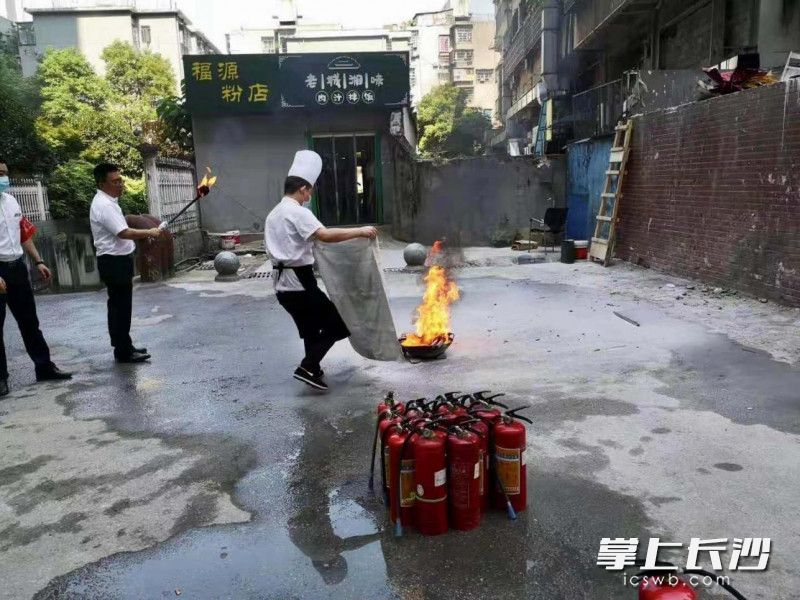 八角亭社區(qū)王府井網(wǎng)格企業(yè)員工在學(xué)習(xí)使用消防毯。楊學(xué)峰 供圖