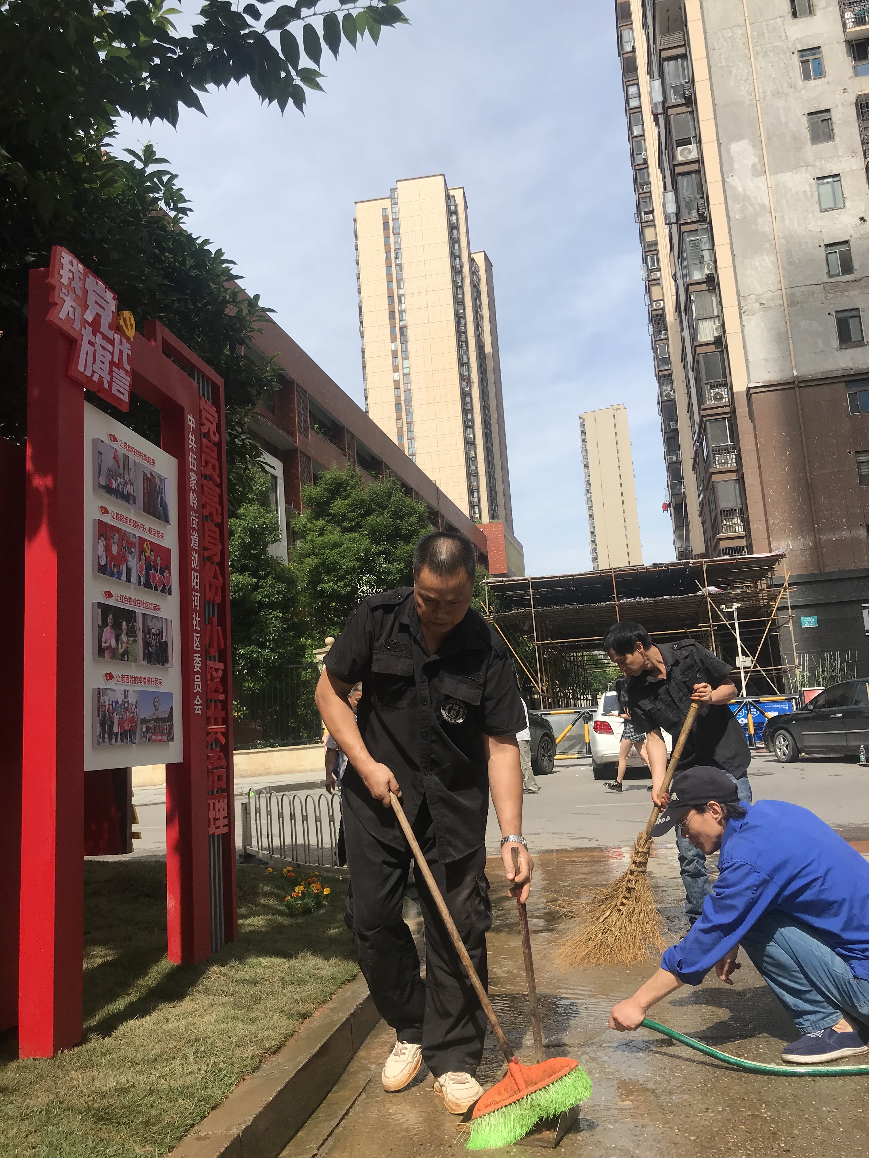 “紅色門牌”立在小區(qū)門口,，黨員和物業(yè)服務人員主動清掃馬路。  長沙晚報全媒體記者 李卓 攝