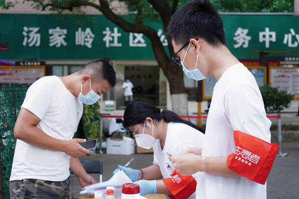 志愿者曾胤哲為居民測量體溫,。