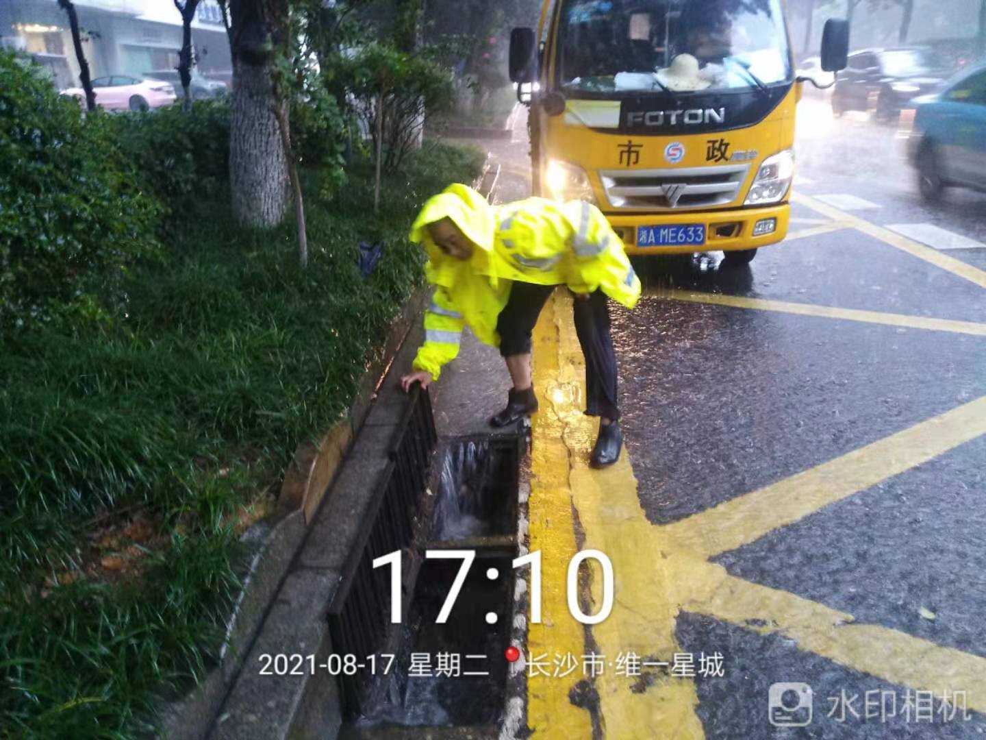 搶險隊員正在韶山路維一星城路段揭蓋助流,。