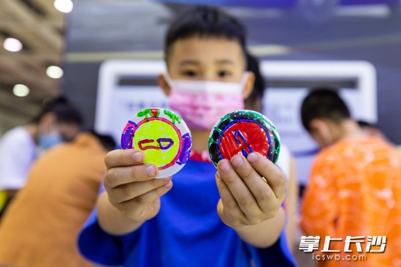 一位小朋友展示自己制作的徽章,。
