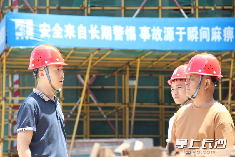 彭文杰（左一）來到建設工地,，叮囑施工方注意安全施工,，及時通過微信群告知業(yè)主代表建設進展情況。 長沙晚報全媒體記者 聶映榮 攝