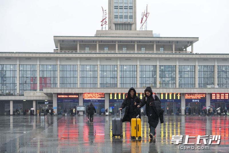 長沙火車站,，冒雨出行的旅客。均為長沙晚報全媒體記者 郭雨滴 攝