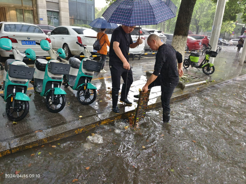 網(wǎng)格員方建興擼起衣袖，冒雨徒手將堵塞在下水道的樹(shù)枝雜物都清理出來(lái),。