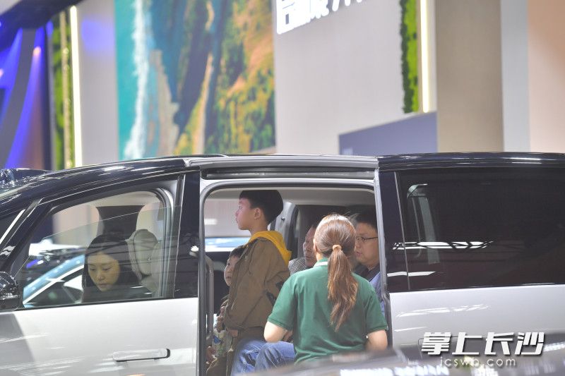 理想汽車展臺,，顧客正坐在車上體驗,。