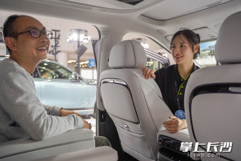 為顧客講解車的同時,，也能考慮顧客的切實需求,，小鵬展臺銷售人員的服務(wù)讓顧客露出笑容,。 