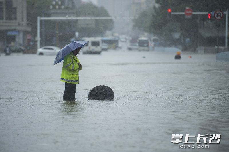 6月24日14時(shí)59分,，芙蓉區(qū)車站中路，市政工作人員守著一處排水井,，提醒著冒險(xiǎn)涉水通行的車輛和行人,。