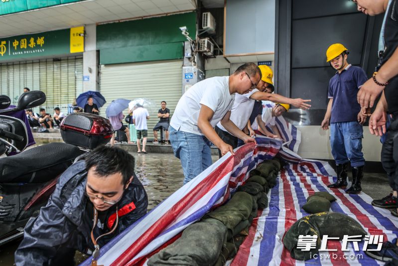 在長沙火車站地鐵站的一個出入口,，工作人員正在進行隔擋，防止積水灌進,。  均為長沙地鐵供圖