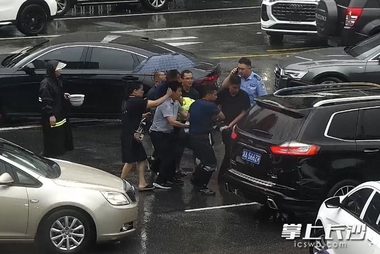 由于路口車輛較多，出于安全考慮,，大家合力將文義軍抬至安全區(qū)域等待救援人員到來,。