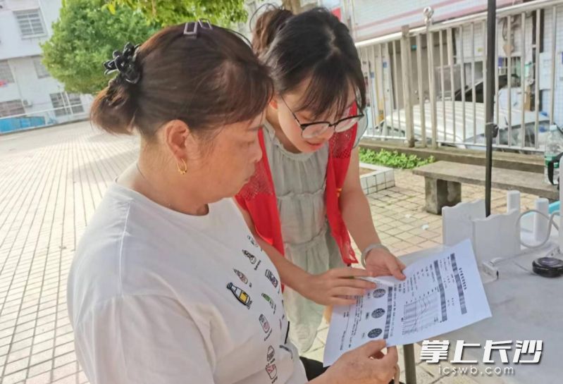 志愿者為居民講解健康情況,。