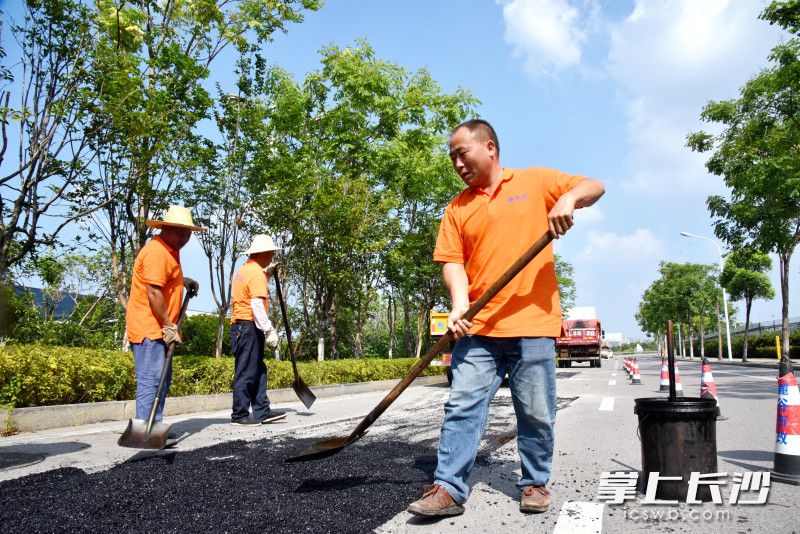 梁國(guó)華和同事們對(duì)破損路面進(jìn)行維護(hù)。  均為長(zhǎng)沙晚報(bào)通訊員朱莉供圖