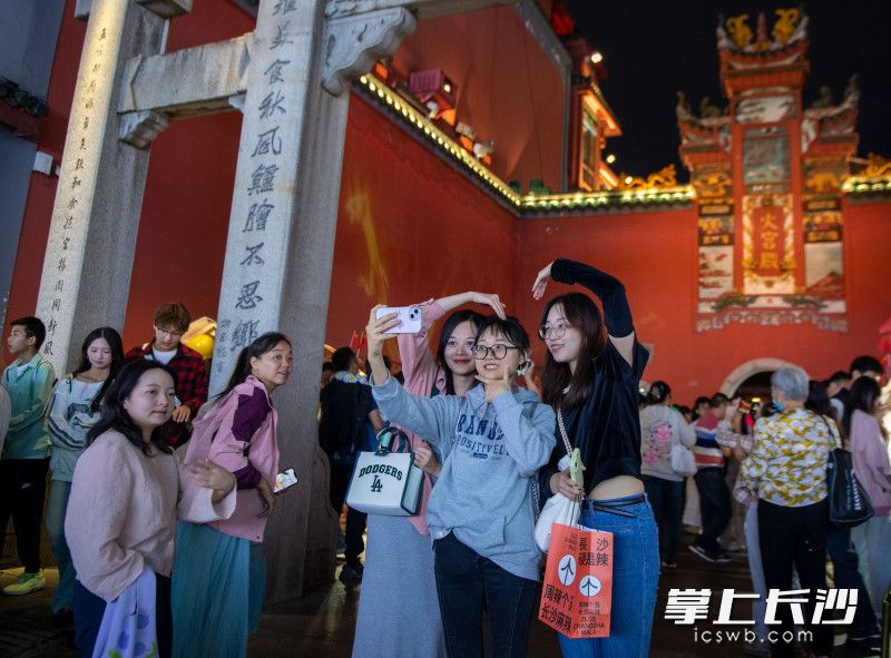 游客們?cè)诨饘m殿前自拍打卡,。