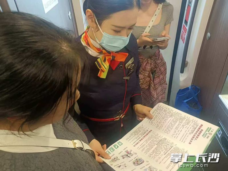 列車員向旅客發(fā)放安全宣傳冊,，講解消防安全知識,。長沙晚報通訊員 戴芳潔 供圖