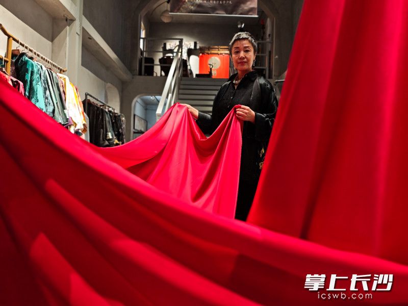 劉珂言為客人展示絲綢布匹,。她說絲綢原本就是中國人的奢侈品，并不是只有國外才能有奢侈品,。