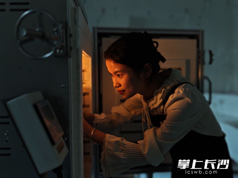 雷雨晴將加工好的燈工玻璃作品放入鍋爐中加熱。