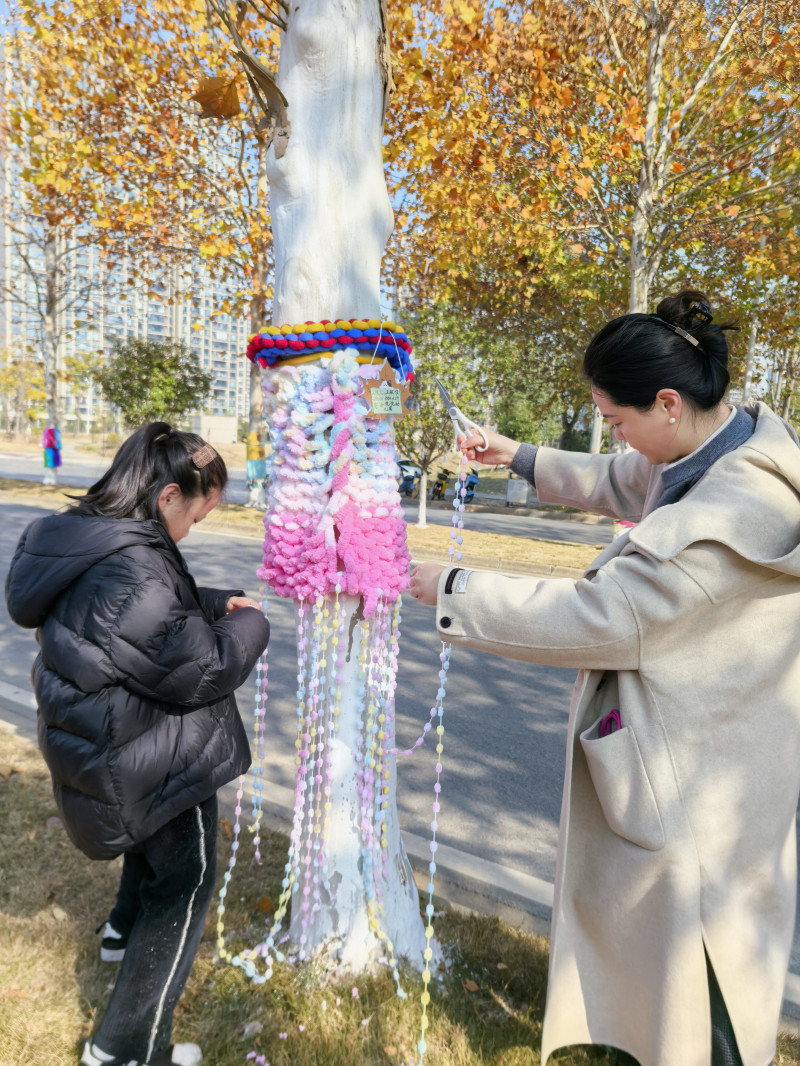 每個小朋友都為自己認領的梧桐樹畫下了“樹衣設計稿”，并邀請爸爸媽媽一同參與制作,。