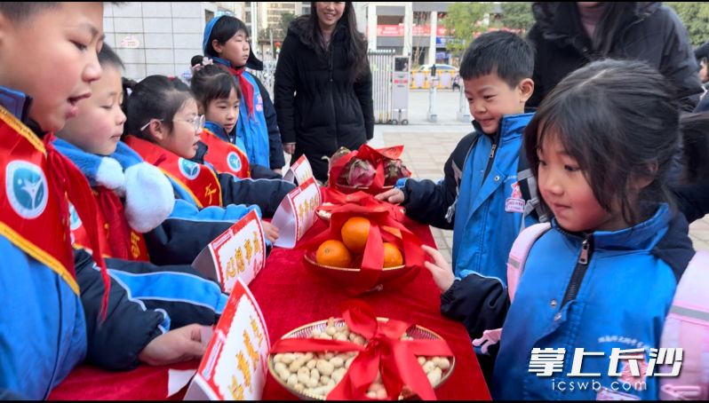 “福運(yùn)長(zhǎng)桌”上面擺著蘋果,、橘子,、甘蔗、火龍果,、花生等,，“雷小鋒”們輕輕觸碰這些寓意祥瑞美好的物品。 均為長(zhǎng)沙晚報(bào)通訊員郭智勇供圖