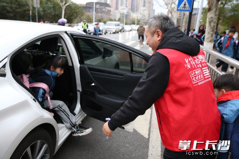 張家貴將孩子接下車,，并一路牽著孩子的手將其護(hù)送進(jìn)學(xué)校,。