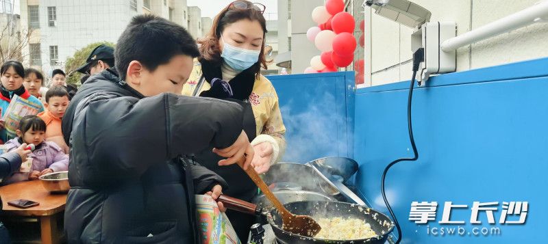 從校長媽媽手里拿過鍋鏟制作揚州炒飯,。  長沙晚報通訊員 鄭薇 趙娟 攝