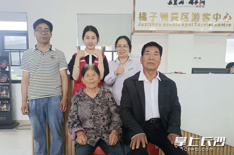 老人一家和景區(qū)工作人員合影,。