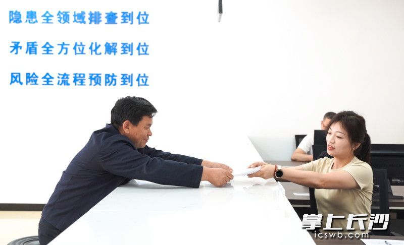 寧鄉(xiāng)市夏鐸鋪鎮(zhèn)綜治中心里,，村民向工作人員遞交申請(qǐng)材料。