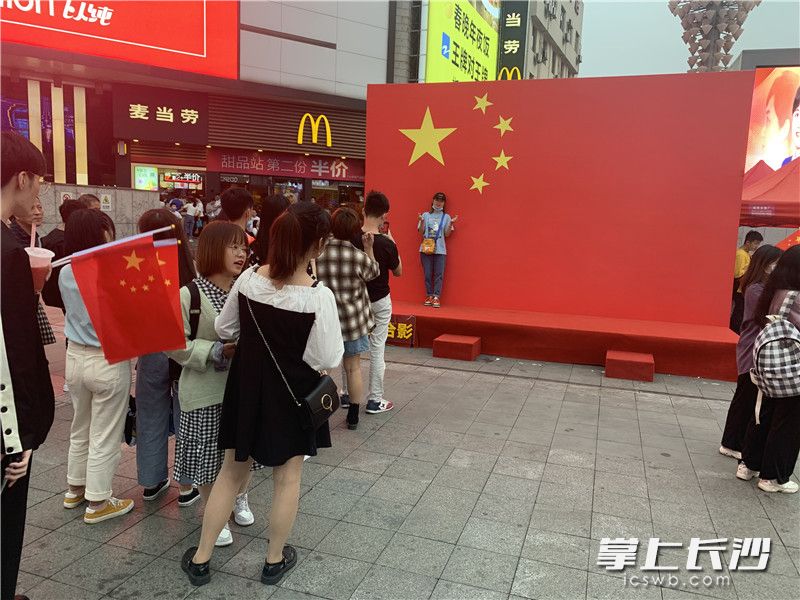 10月1日,，黃興南路步行商業(yè)街巨型國(guó)旗前,，排隊(duì)拍照的游客眾多。
