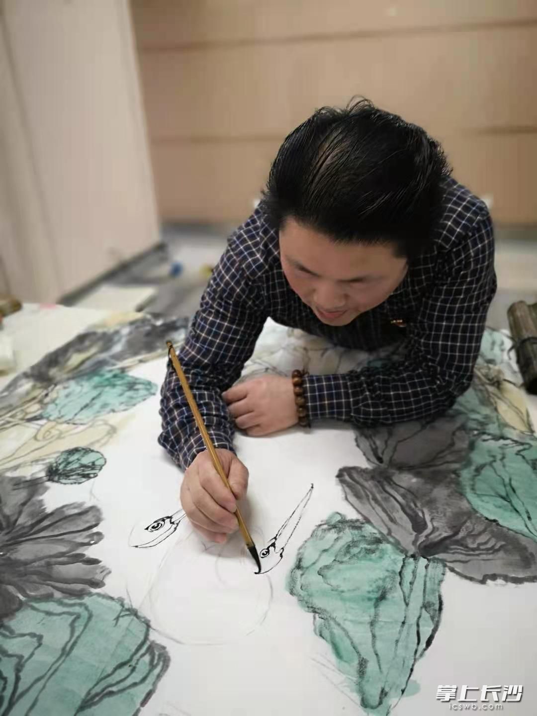 長(zhǎng)沙晚報(bào)資深美編,、青年畫家吳志立正在創(chuàng)作名為《家園》的國(guó)畫。長(zhǎng)沙晚報(bào)全媒體記者 楊蔚然 攝
