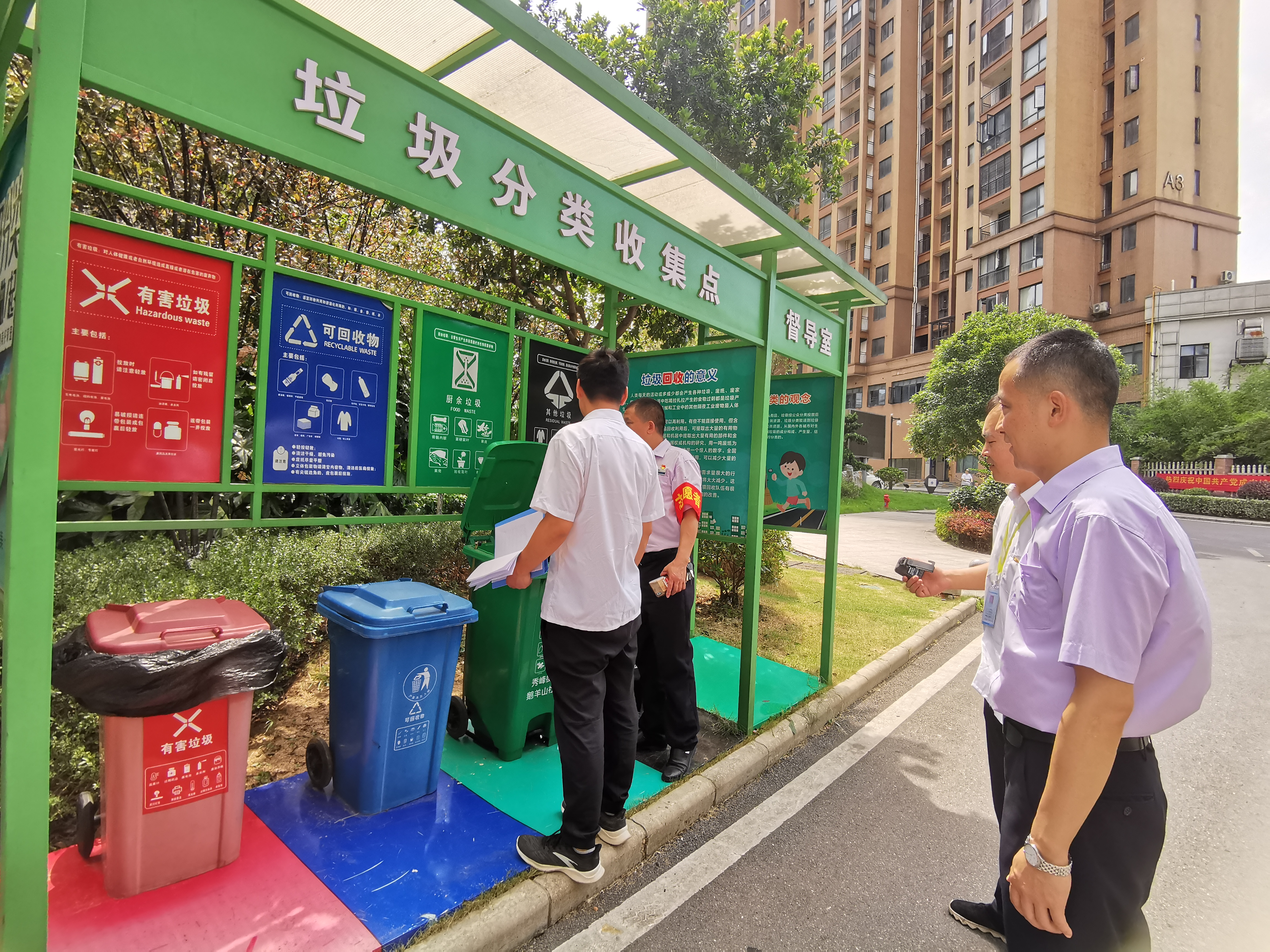 執(zhí)法人員正在垃圾分類收集點(diǎn)檢查垃圾分類情況,。