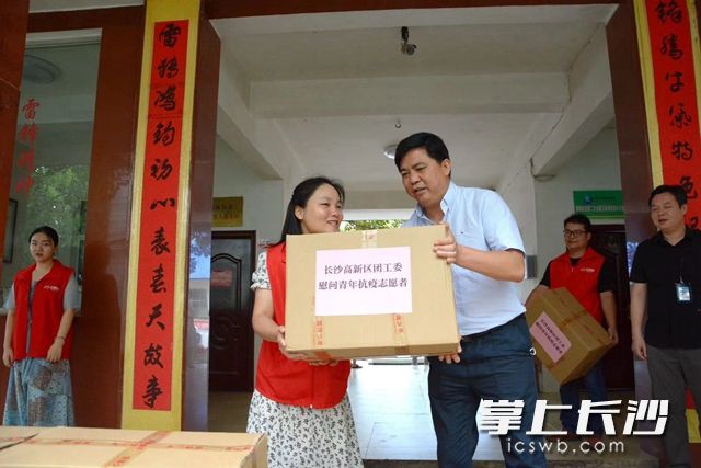 長沙高新區(qū)黨群工作局副局長伍秋陽（右）帶隊(duì)送去慰問物資,。