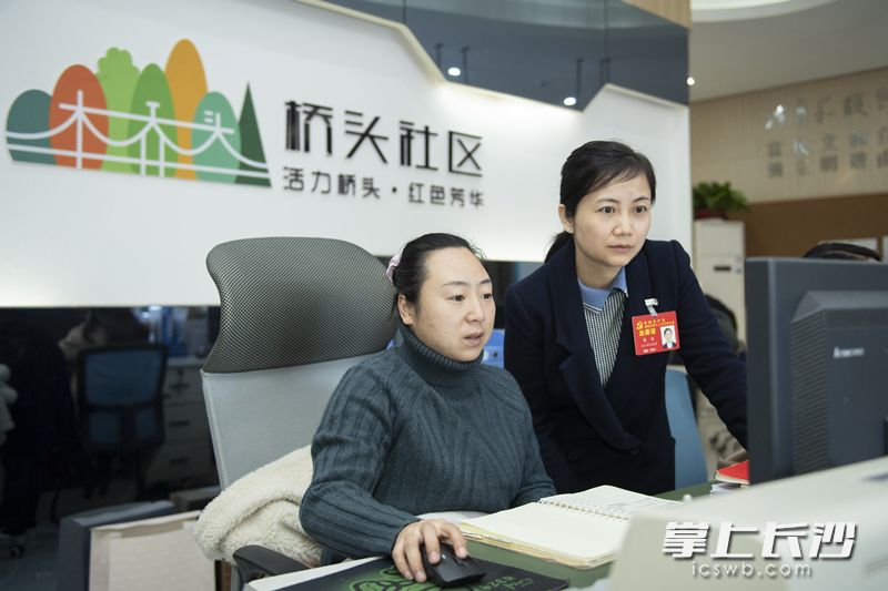 康姣在和同事一起處理社區(qū)工作,。