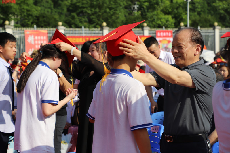 金海教育集團(tuán)董事長楊建新給學(xué)生戴成人帽,。