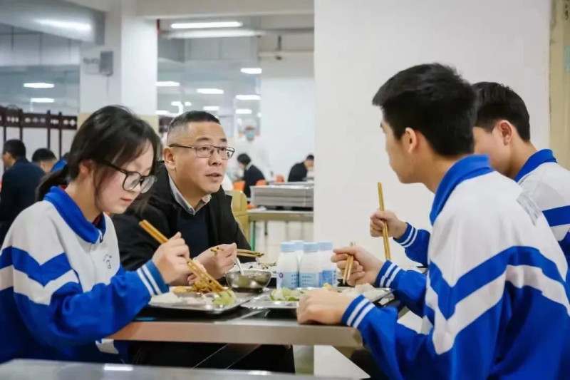 學(xué)校推行陪餐制，保證食堂飲食質(zhì)量,。圖為長沙市實(shí)驗(yàn)中學(xué)黨委書記肖建軍（左二）跟學(xué)生一起進(jìn)餐,。資料圖片